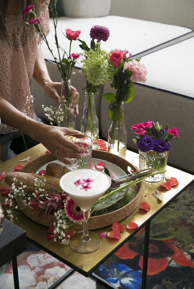 We kunnen dan wel richting winter gaan, maar in mijn hoofd is het nog volop zomer. Helemaal toen ik afgelopen weekend een shoot vol met bloemen had. Ik stylede mijn salontafeltjes geheel in de French Apéro stijl waar naast de hapjes uiteraard de zee aan bloemen alle aandacht trok. Nu ben ik niet vies van eten. Sterker nog: het liefst eet ik de hele dag door. Naast het toetje is ook zeker het aperitief favoriet bij mij. Tijdens mijn Toscaanse honeymoon at ik elke dag anti pasti, maar voor deze shoot staat de French Apéro centraal; een chic aperitiefje op z'n Frans, compleet met een baguette, Franse worst, kaasjes, groentechips en een mierzoete cocktail. Maar het zijn juist de bloemen waar ik even meer over wil vertellen, want deze fleurige figuranten uit deze smakelijke shoot zijn onmisbaar voor deze herfst. Ik som hieronder mijn favorieten op. Mijn salontafel gestyled met bloemen: French Apéro style! Een chrysant vol geluk De ultieme herfstbloem is natuurlijk de chrysant, uiteraard in zijn oorspronkelijke goudgele kleur. Ik weet niet beter dan dat mijn moeder tijdens de herfst altijd chrysanten kocht (en mij nog altijd elk jaar een bosje chrysanten geeft). Deze 'gouden' bloem , die trouwens ook in andere kleuren verkrijgbaar is, brengt warmte en kleur in je huis én staat voor geluk en gezondheid. En laten we nou net dat laatste nodig hebben tijdens de gure herfstmaanden. Voor altijd de jouwe met de Dahlia Een andere eyecatcher uit deze shoot is de Dahlia. Fotografeerde ik afgelopen jaar een enorme bos Dahlia's in mijn woonkamer, dit keer koos ik voor een iets subtieler exemplaar in een paarse kleur. Ik vind deze zo mooi: hij lijkt bijna nep. Deze Mexicaanse schone komt met de betekenis 'voor altijd de jouwe'. Past dus precies in mijn huis. Mijn salontafel gestyled met bloemen: French Apéro style! Bloem vol hartstocht, verlangen en romantiek Nog zo'n romantische bloem is de anjer, een bloem die nooit verveelt, omdat de anjer verschillende vormen en kleuren heeft. Voor deze shoot nam ik een felroze, een van mijn lievelingskleuren voor bloemen. Hij zit gezellig in een flesje met gipskruid en de distel. Deze laatste heeft niet zo'n mooie betekenis (afweer, zorg en kommer), maar steekt qua kleur mooi af bij de rest. En wist je dat gipskruid in de verte familie is van de anjer? Mijn salontafel gestyled met bloemen: French Apéro style! Gerbera Verrassend maar waar, maar de gerbera heeft én geen geur én geen symboliek. Toch vond ik dat deze bloem niet mocht ontbreken op mijn salontafel. Ik knipte de gerbera extra korte en stylede 'm in twee glaasjes. salontafel-bloemen-interiorjunkie25 * Dit is een inspirerende samenwerking met Bloemenbureau Holland. Door samen te werken met merken, kan Interior Junkie blijven bestaan. Thanks voor de support!